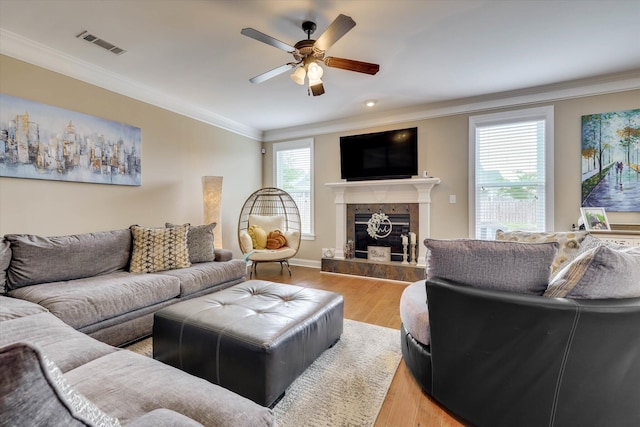 living room featuring visible vents, wood finished floors, a ceiling fan, and ornamental molding