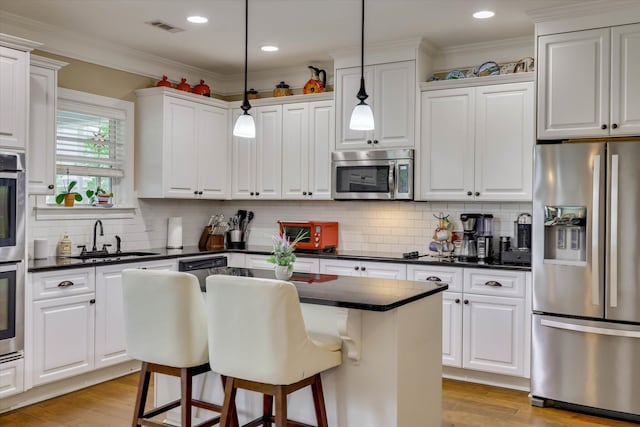 kitchen featuring white cabinetry, light wood-style flooring, a sink, appliances with stainless steel finishes, and visible vents