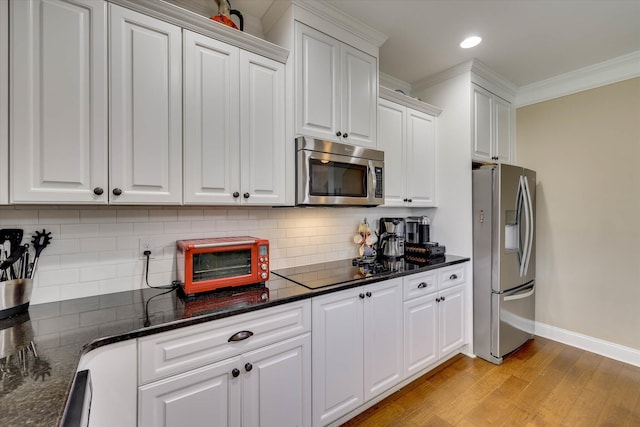 kitchen featuring white cabinetry, stainless steel appliances, a toaster, ornamental molding, and light wood finished floors