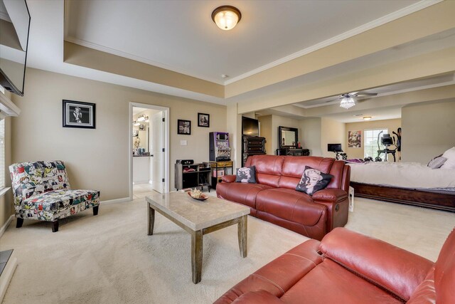 living area with crown molding, a raised ceiling, baseboards, light carpet, and a ceiling fan