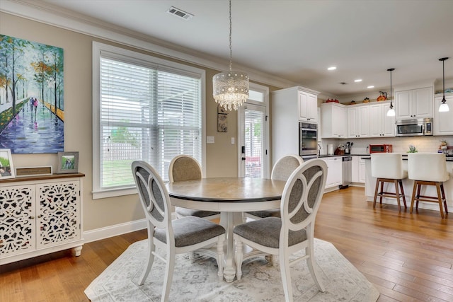 dining room featuring a chandelier, a healthy amount of sunlight, and hardwood / wood-style floors
