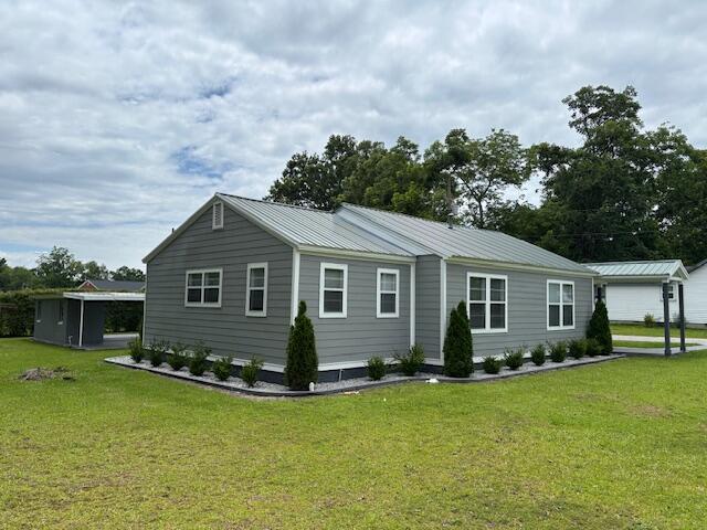 641 Ellington Ave, Thomson, GA 30824 - view of property exterior with a lawn and metal roof