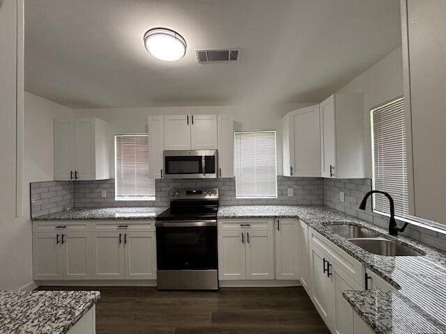 641 Ellington Ave, Thomson, GA 30824 - kitchen with stainless steel appliances, a sink, white cabinetry, light stone counters, and dark wood-style flooring