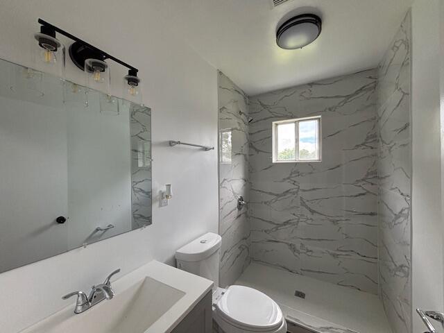 641 Ellington Ave, Thomson, GA 30824 - bathroom with toilet, vanity, and a marble finish shower