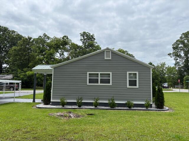 641 Ellington Ave, Thomson, GA 30824 - view of side of property featuring a yard, a carport, and concrete driveway