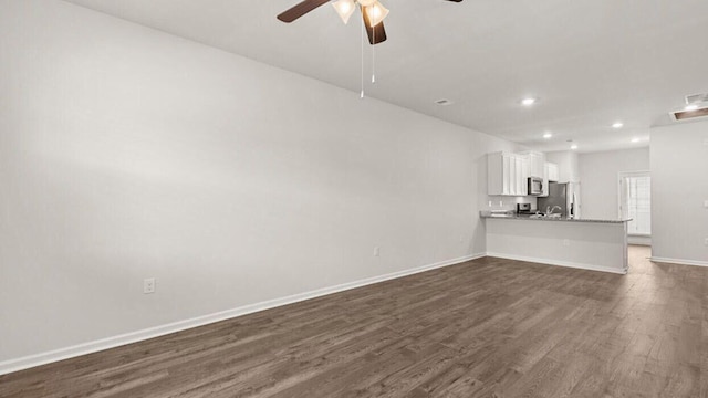 unfurnished living room with ceiling fan and dark hardwood / wood-style floors