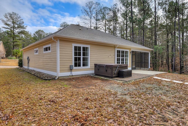 back of property featuring a patio and a hot tub