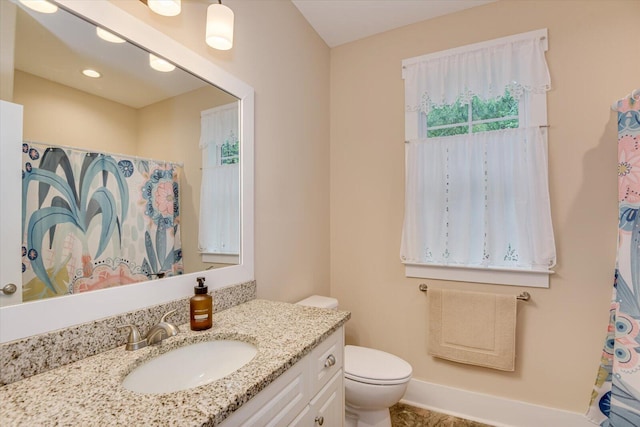 bathroom featuring a shower with shower curtain, vanity, and toilet