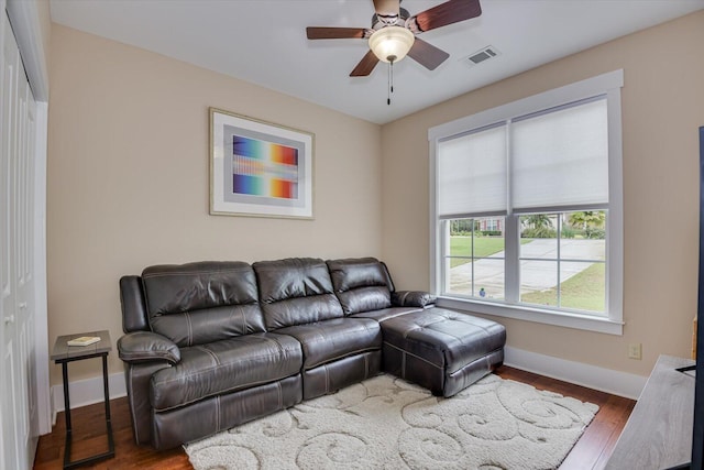 living room featuring ceiling fan and dark hardwood / wood-style floors