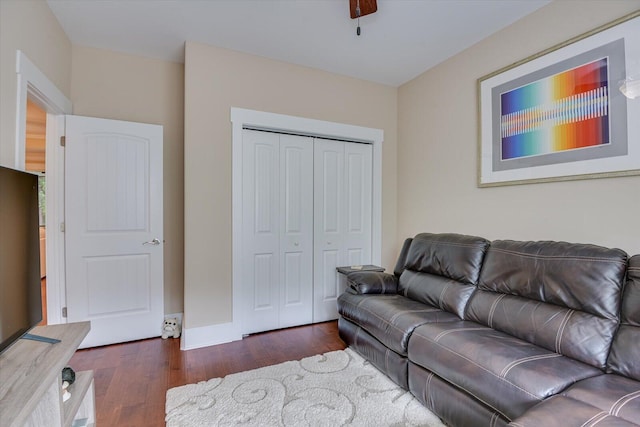 living room featuring ceiling fan and dark hardwood / wood-style flooring