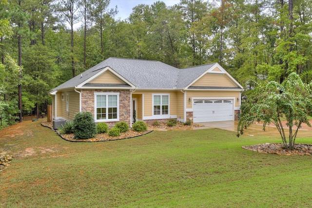 view of front of home featuring cooling unit, a front yard, and a garage