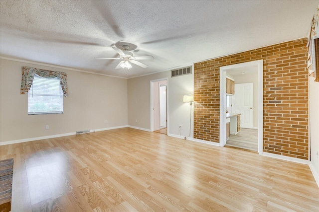 empty room with ceiling fan, ornamental molding, a textured ceiling, and light wood-type flooring