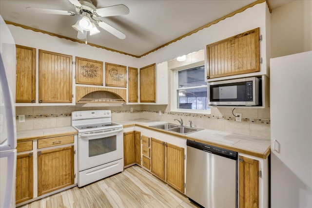 kitchen with sink, appliances with stainless steel finishes, tasteful backsplash, ventilation hood, and tile counters