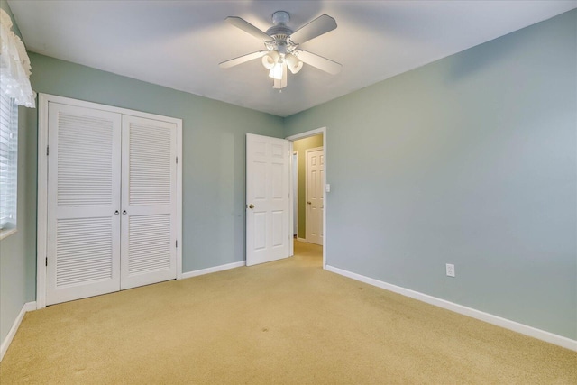 unfurnished bedroom with ceiling fan, a closet, and light carpet