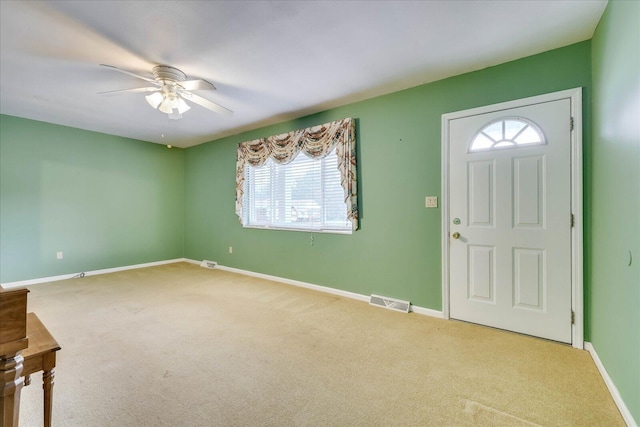 carpeted foyer featuring ceiling fan