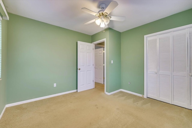 unfurnished bedroom with light colored carpet, ceiling fan, and a closet