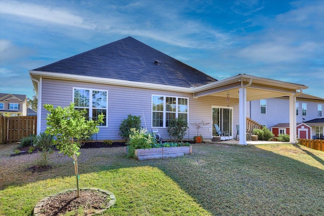 rear view of property featuring a storage unit and a lawn