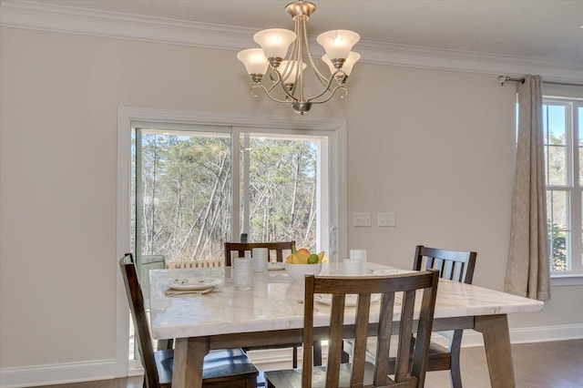 dining area with ornamental molding, dark hardwood / wood-style floors, and an inviting chandelier