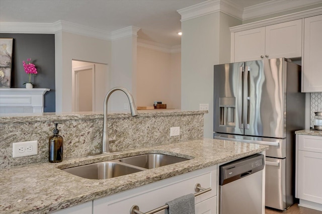 kitchen with appliances with stainless steel finishes, tasteful backsplash, sink, white cabinets, and light stone countertops