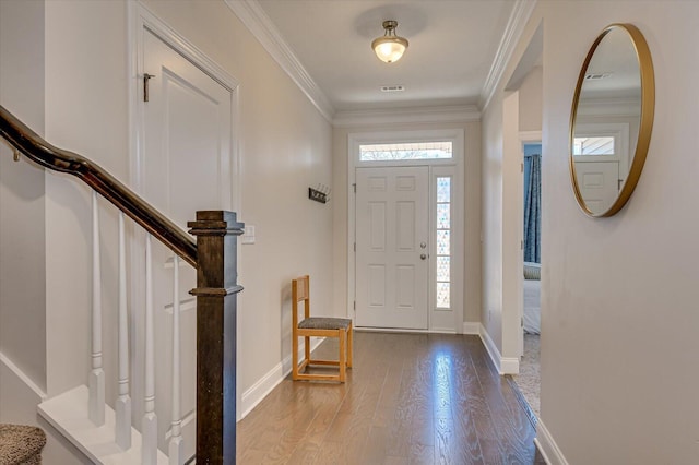 entryway with ornamental molding and hardwood / wood-style floors