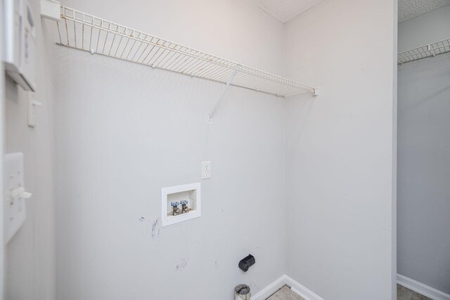 laundry room featuring washer hookup and a textured ceiling