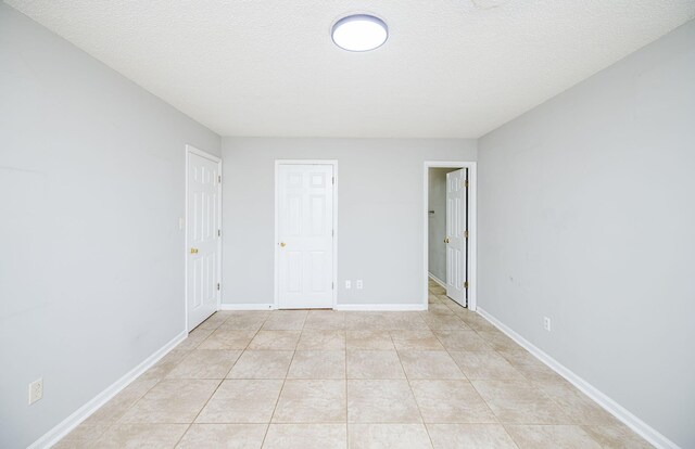 unfurnished bedroom featuring light tile patterned floors and a textured ceiling