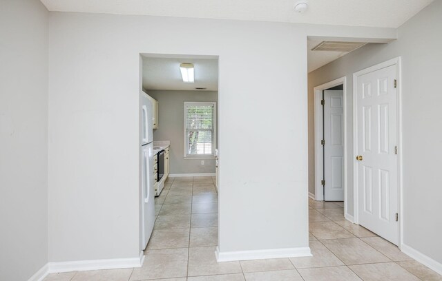 interior space with electric stove and light tile patterned floors