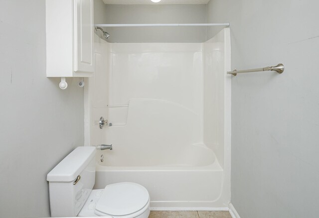 bathroom with tile patterned flooring, toilet, and shower / bathtub combination