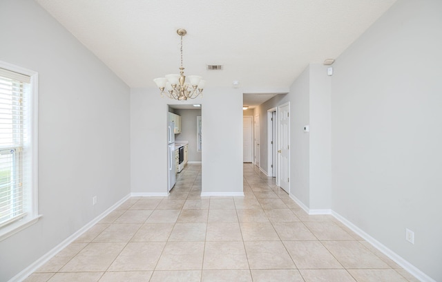 interior space with light tile patterned floors and a chandelier