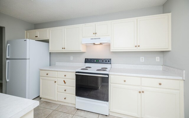 kitchen with a textured ceiling, white cabinets, light tile patterned floors, and white appliances