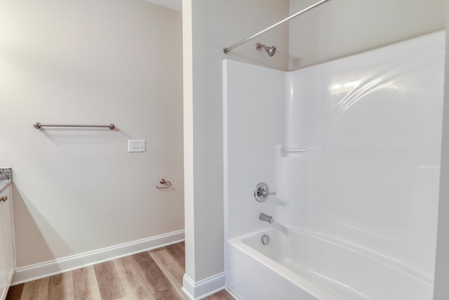 bathroom featuring hardwood / wood-style flooring, vanity, and  shower combination