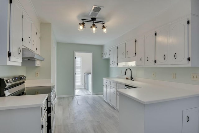 kitchen featuring stainless steel electric stove and white cabinets