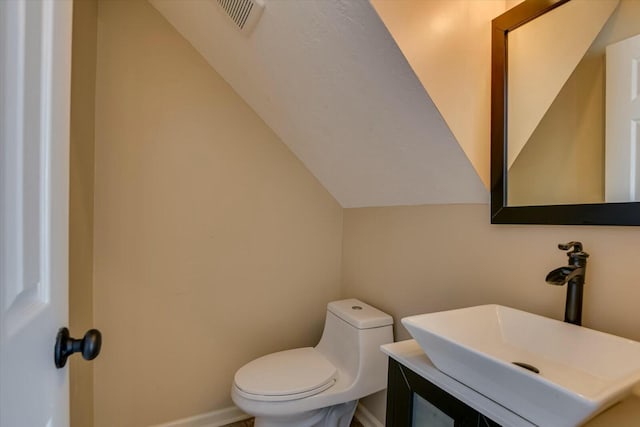 bathroom with vanity, vaulted ceiling, and toilet