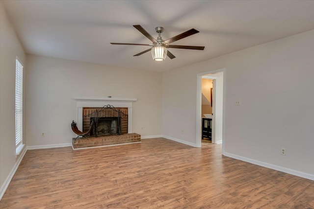 unfurnished living room with ceiling fan, a fireplace, and light hardwood / wood-style flooring