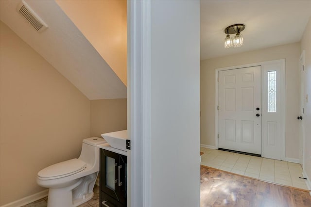 foyer with vaulted ceiling and light wood-type flooring