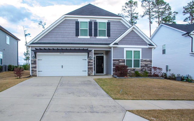 craftsman inspired home featuring driveway, a garage, stone siding, cooling unit, and a front lawn