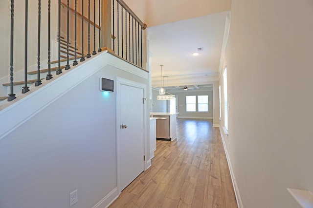 interior space featuring ornamental molding and light wood-type flooring