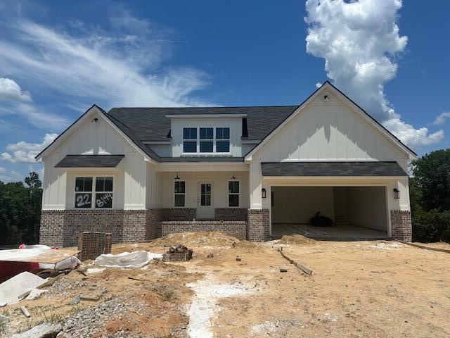 8144 Crossbow Lndg, Graniteville, SC 29829 - view of front of home with brick siding, board and batten siding, an attached garage, roof with shingles, and a porch