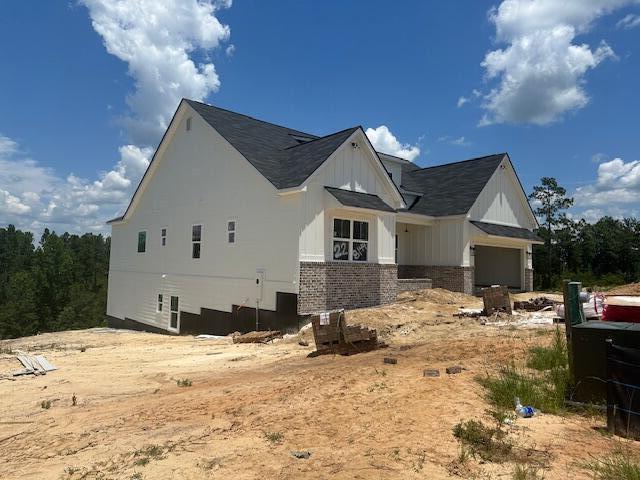 8144 Crossbow Lndg, Graniteville, SC 29829 - view of side of property featuring brick siding, board and batten siding, a garage, and roof with shingles