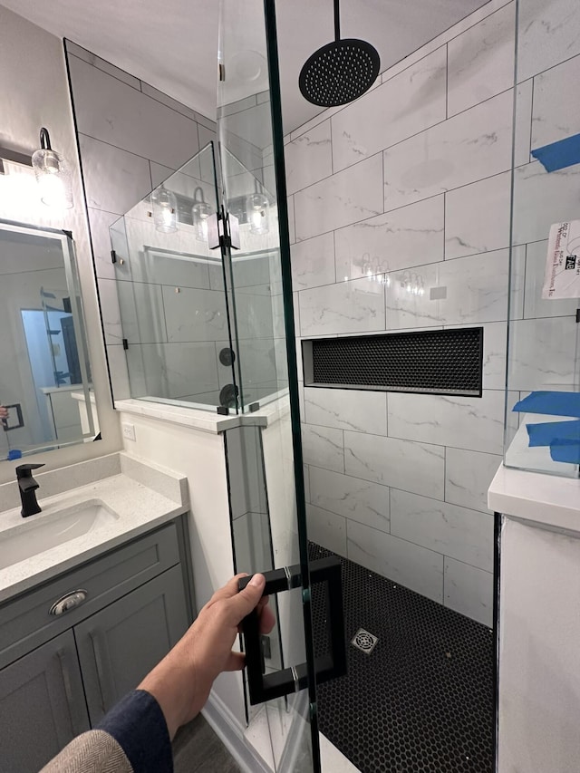 bathroom featuring a tile shower and vanity