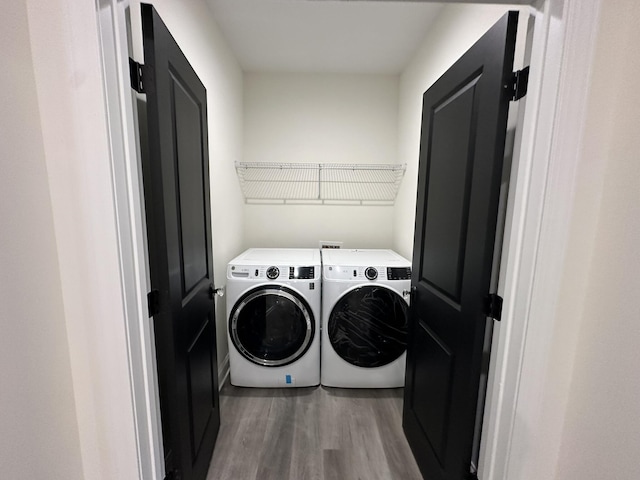 laundry area with separate washer and dryer and hardwood / wood-style floors