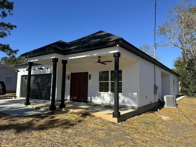 view of front of home with a porch, a garage, ceiling fan, and central air condition unit