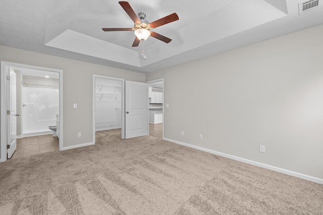 1006 Rosendale Dr, Hephzibah, GA 30815 - unfurnished bedroom with a raised ceiling, carpet flooring, a spacious closet, connected bathroom, and a ceiling fan