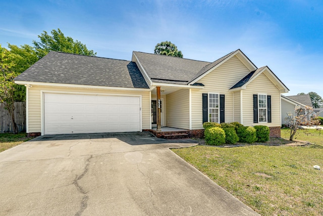 ranch-style home with fence, a front yard, a shingled roof, an attached garage, and driveway
