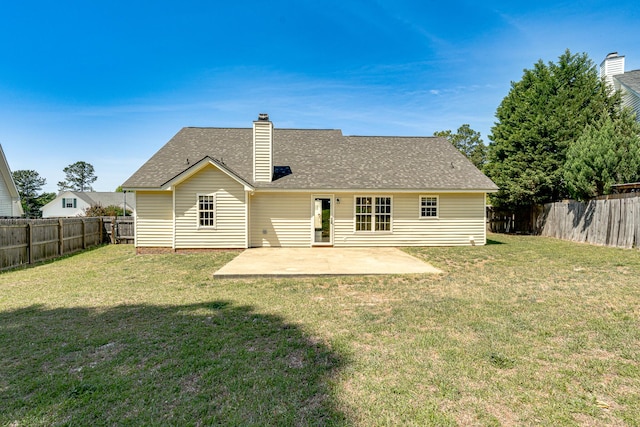 rear view of house featuring a yard, a fenced backyard, and a patio area
