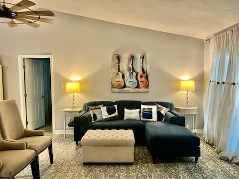 interior space featuring ceiling fan, vaulted ceiling, and baseboards