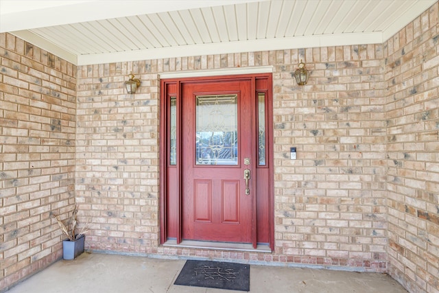 view of exterior entry featuring brick siding