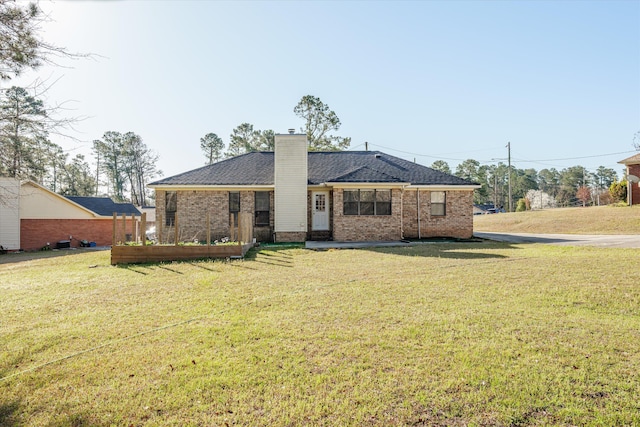 ranch-style house with a front yard, brick siding, and a chimney