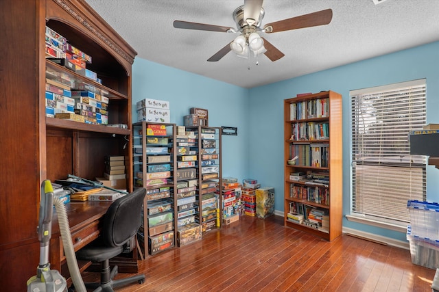 home office with hardwood / wood-style floors, a ceiling fan, and a textured ceiling