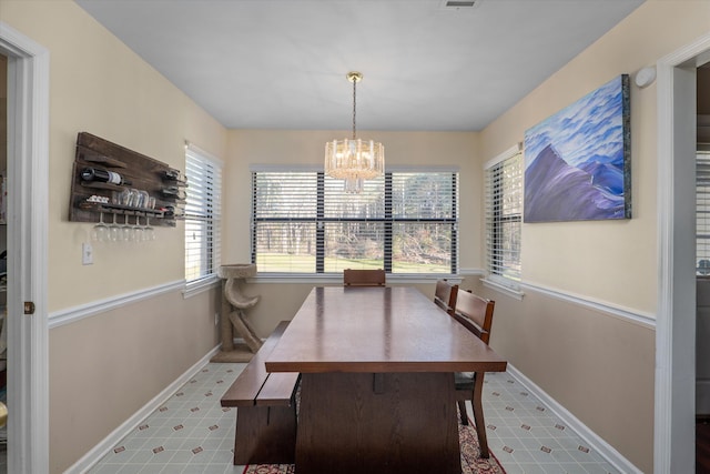 dining area with a healthy amount of sunlight, baseboards, and an inviting chandelier